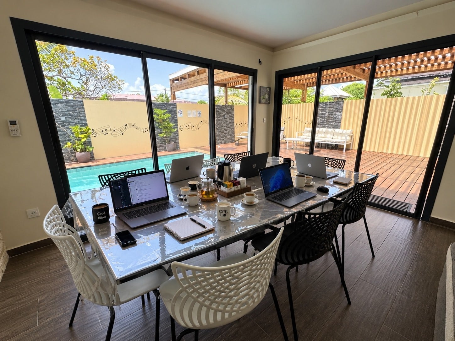 A meeting around the table, the glass doors open onto the deck