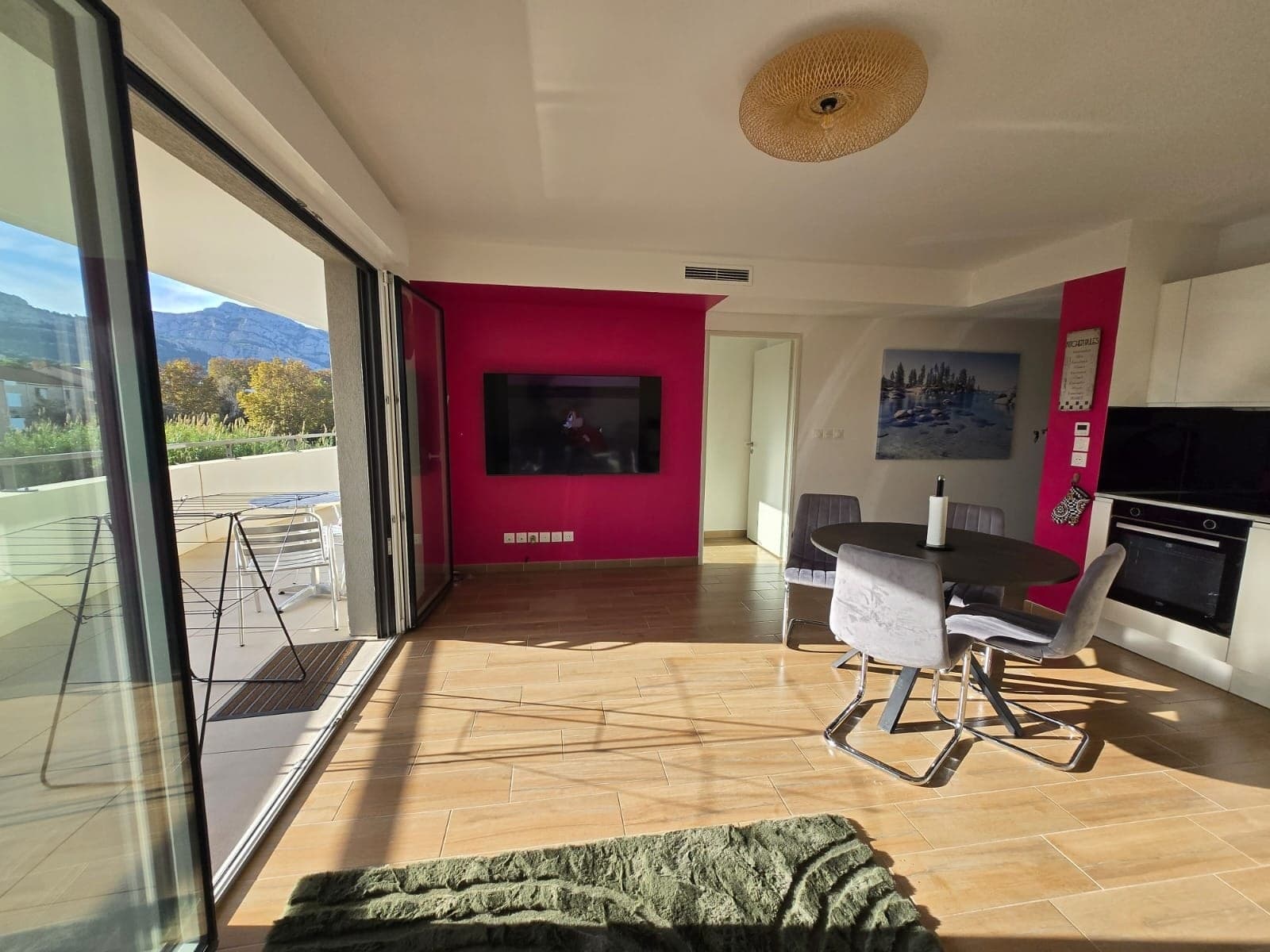 The bright living room, glass doors opening onto the hills